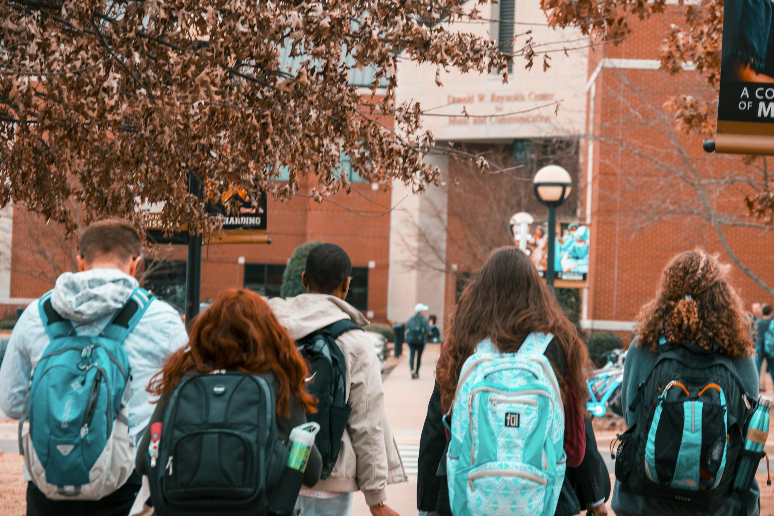 A group of students with backpacks walking together outdoors on campus.